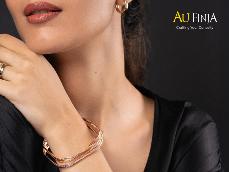 Gold bangles and a ring on a textured background, symbolizing strength and elegance for International Women’s Day gifts.